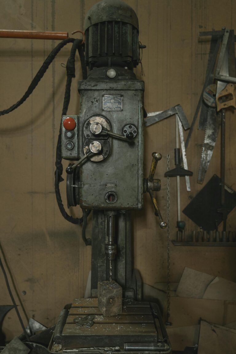 Close-up of a vintage drilling machine in an industrial workshop, highlighting its mechanical details.